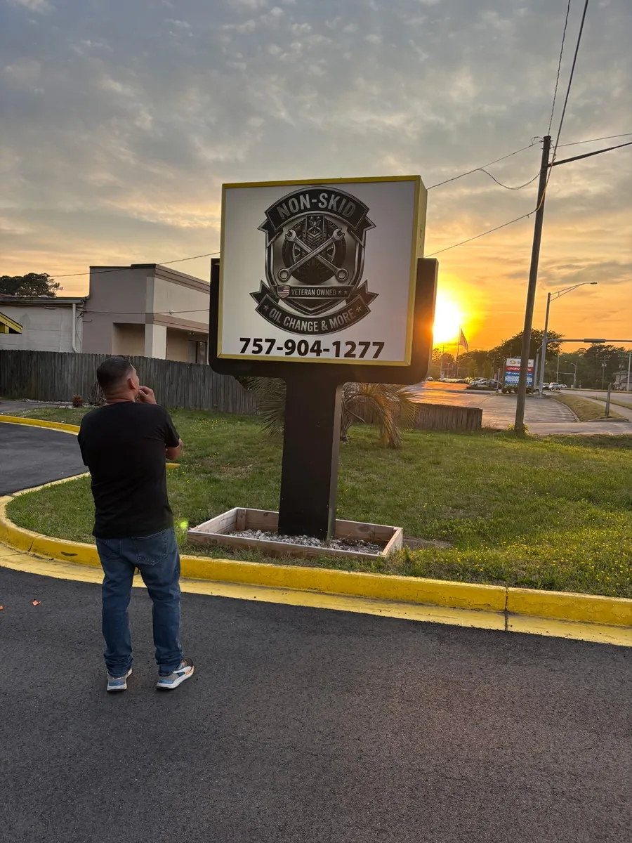 Non-Skid Oil Change and More road sign at sunset