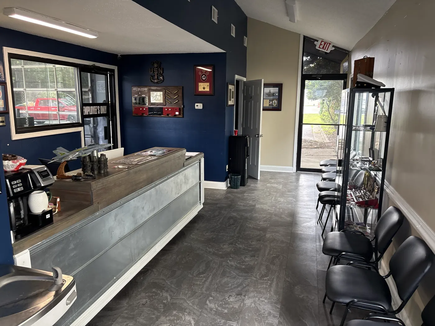 Non-Skid Oil Change and More waiting room with seating, service counter and a wall of Navy memorabilia